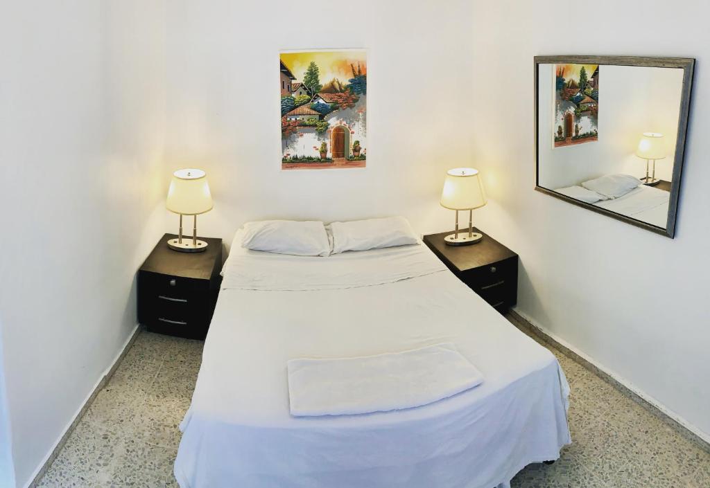 two beds in a room with two lamps and a mirror at Palmira Hostel in Tegucigalpa