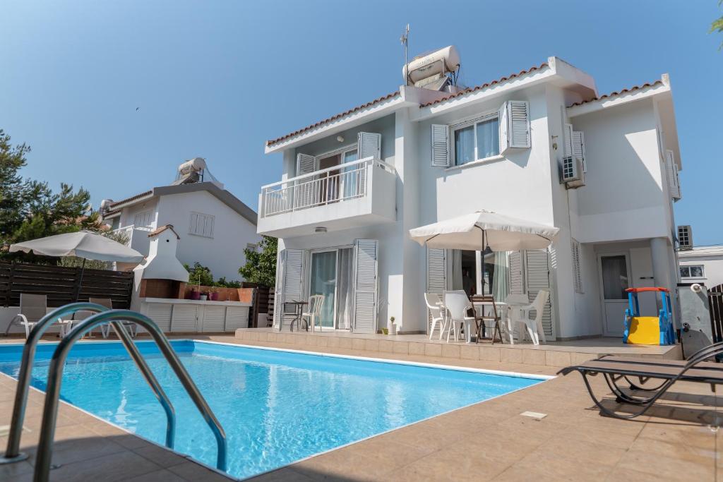 uma villa com uma piscina e uma casa em Sun & Sand Private Villa em Protaras