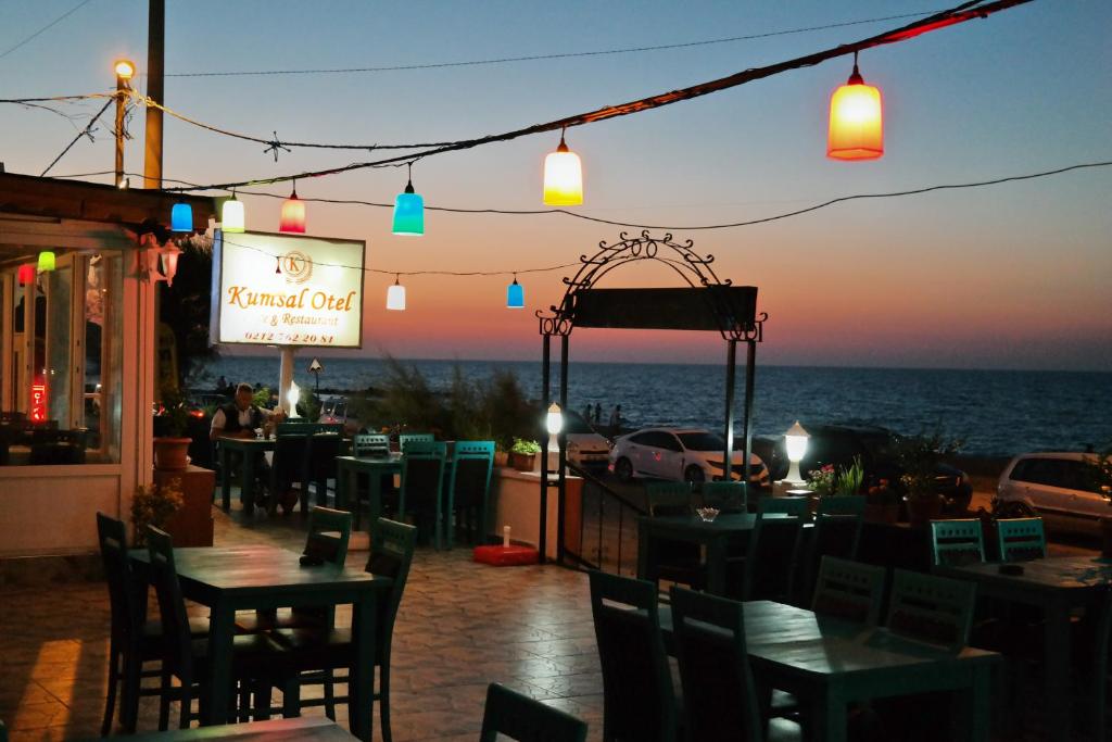 a restaurant with tables and chairs with a view of the ocean at istanbul Airport Kumsal Otel in Arnavutköy