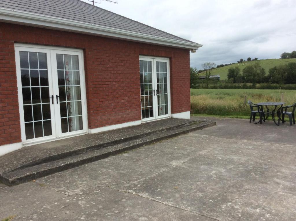 a red brick building with a patio and a table at Rathgillen Mews in Nobber