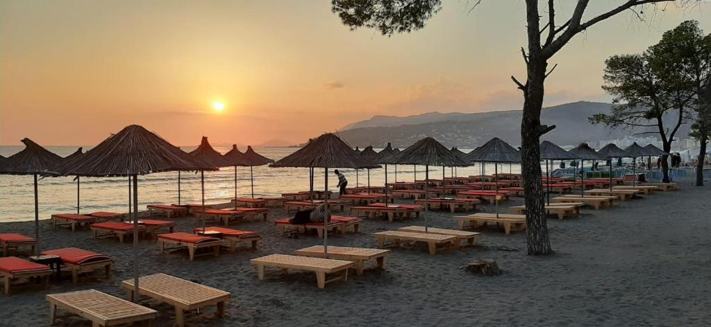 a group of tables and umbrellas on a beach at Nada SeaView Apartment in Shëngjin