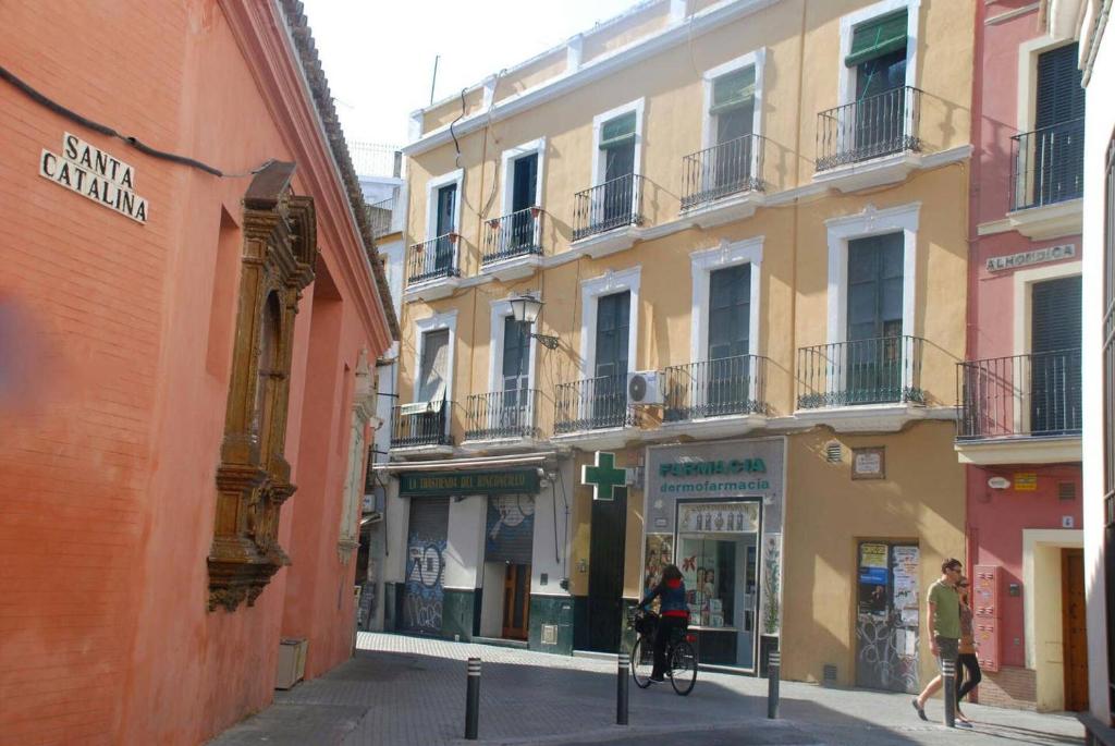 una persona que va en bicicleta por una calle con edificios en Apartamento Centro Santa Catalina 1º B, en Sevilla