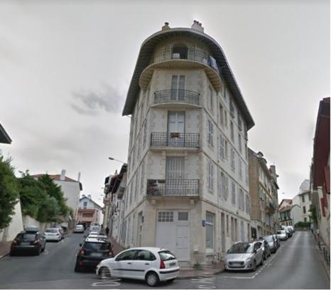 a tall building with a round roof on a city street at Logement hyper centre et près de la plage 1er étage in Biarritz