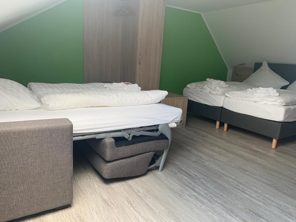 2 camas individuales en una habitación con paredes verdes en Hotel Unter den Linden en Kierspe