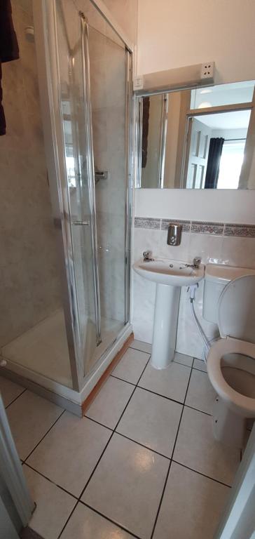 Un baño con ducha, inodoro y lavabo. en Liberty House - Bundoran seaside family & surfers holiday home, en Single Street