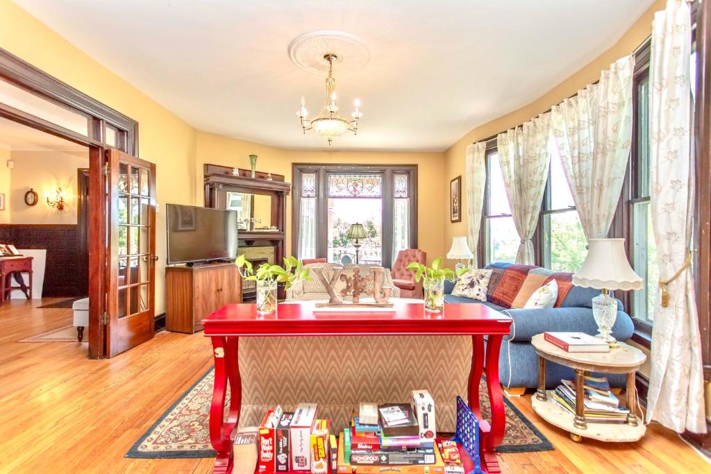 uma sala de estar com uma mesa vermelha com livros em Redwood Bed and Breakfast em Cataratas do Niágara