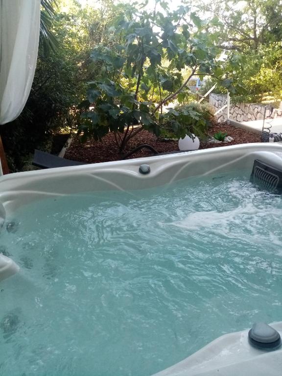 a hot tub with blue water in a yard at Villa deluxe "H" - private jacuzzi in Novi Vinodolski