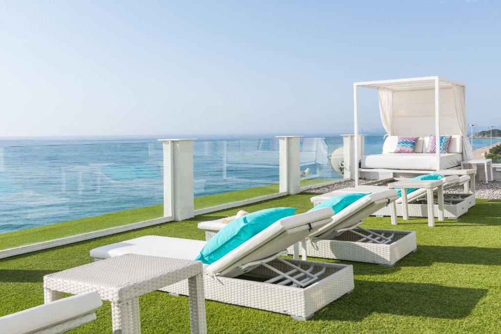 einen Balkon mit Stühlen, einem Bett und Meerblick in der Unterkunft Hotel Planamar by Escampa Hotels in Platja  d'Aro