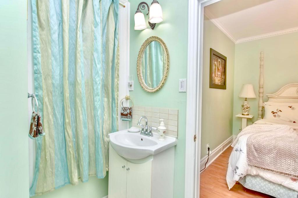 a bathroom with a sink and a bed and a mirror at Redwood Bed and Breakfast in Niagara Falls