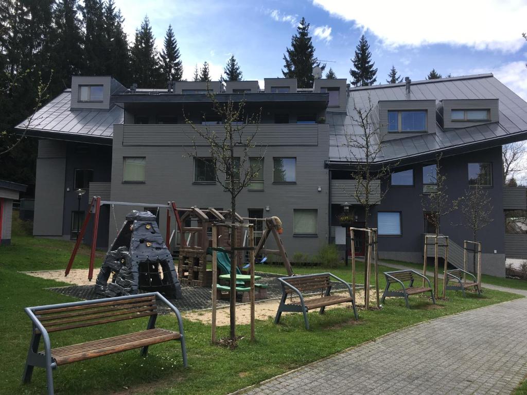 a playground with benches in front of a building at Apartman Harrachov in Harrachov