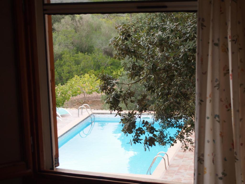 a view of a swimming pool through a window at Villa S´Alzina in Sencelles