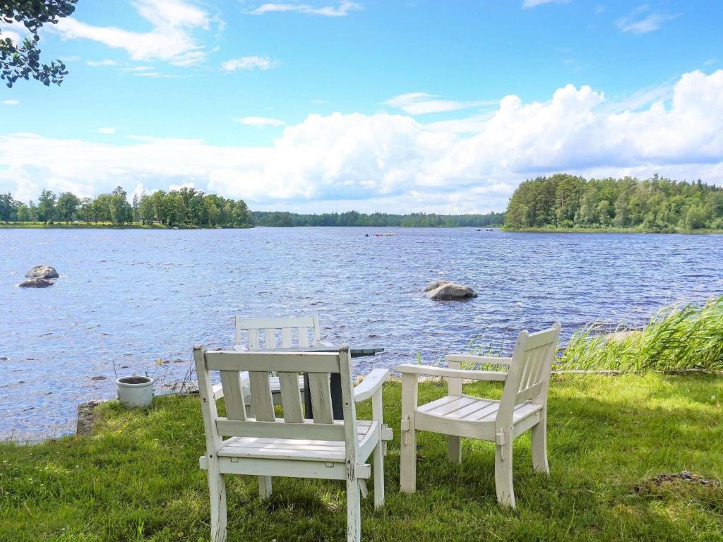 zwei Stühle und ein Tisch vor einem See in der Unterkunft 5 person holiday home in TINGSRYD in Tingsryd