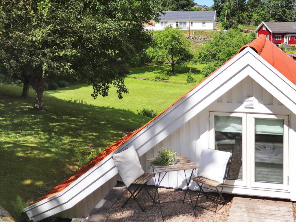 a small white shed with a table and two chairs at 4 person holiday home in Veddige in Veddige