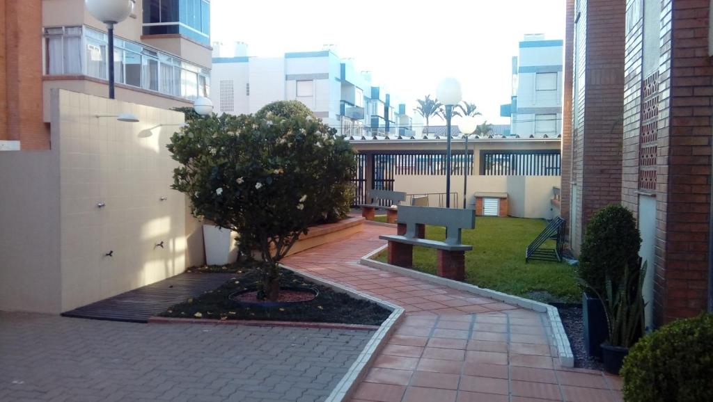 a park bench in the middle of a courtyard at LINDO AP CAPAO NOVO in Capão da Canoa