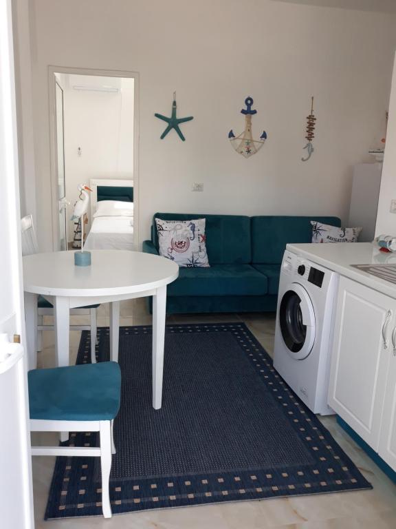 a living room with a white table and a blue couch at Blue Coral apartament in Velipojë