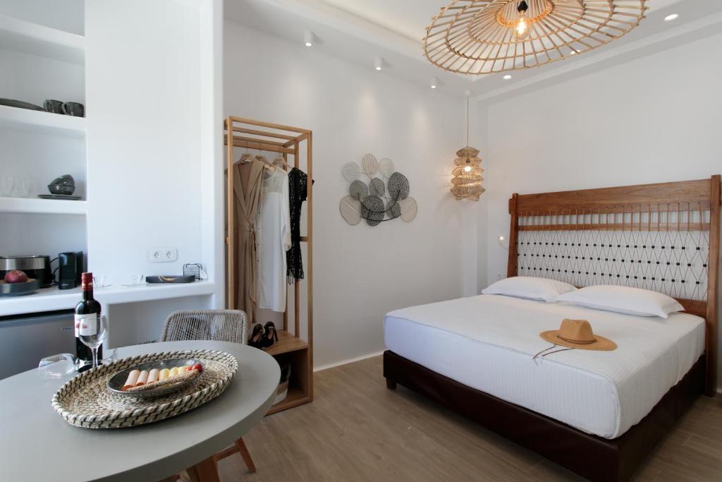a bedroom with a bed and a table with a hat on it at Hora Seaside Suites in Naxos Chora