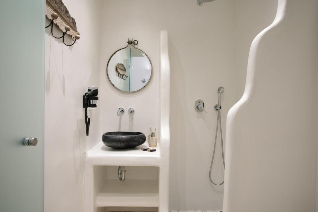 a bathroom with a sink and a mirror at Hora Seaside Suites in Naxos Chora