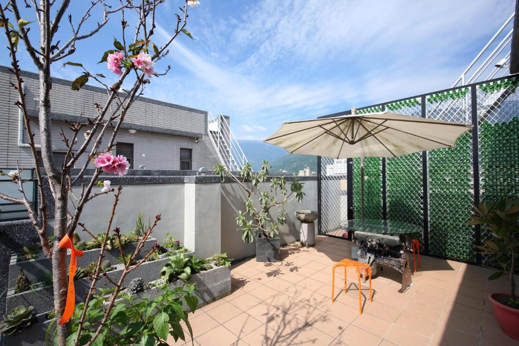 a patio with an umbrella and a table and chairs at Ji Ye Jing Zhan B&amp;B in Ji&#39;an
