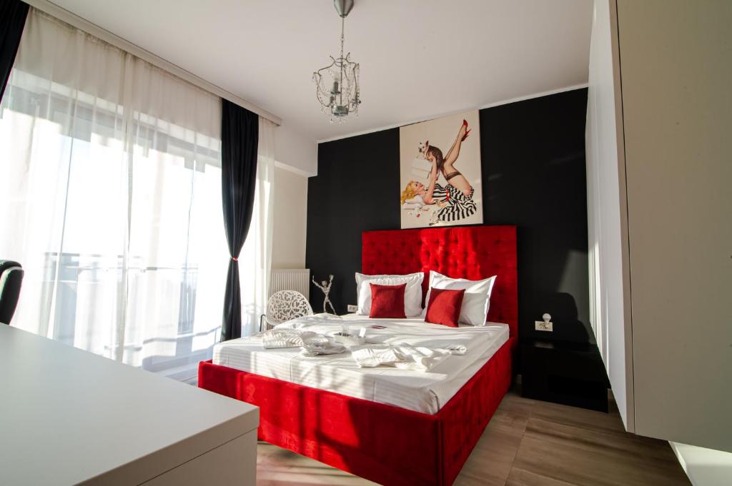 a bedroom with a bed with a red headboard at BLISS Apartment in Constanţa