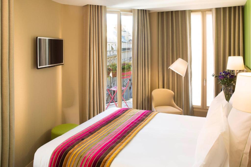 Habitación de hotel con cama y ventana en Hôtel Cordelia Opéra-Madeleine en París