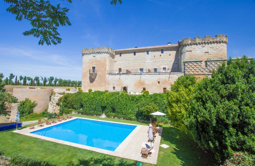 uma vista exterior de um castelo com uma piscina em Posada Real Castillo del Buen Amor em Villanueva de Cañedo