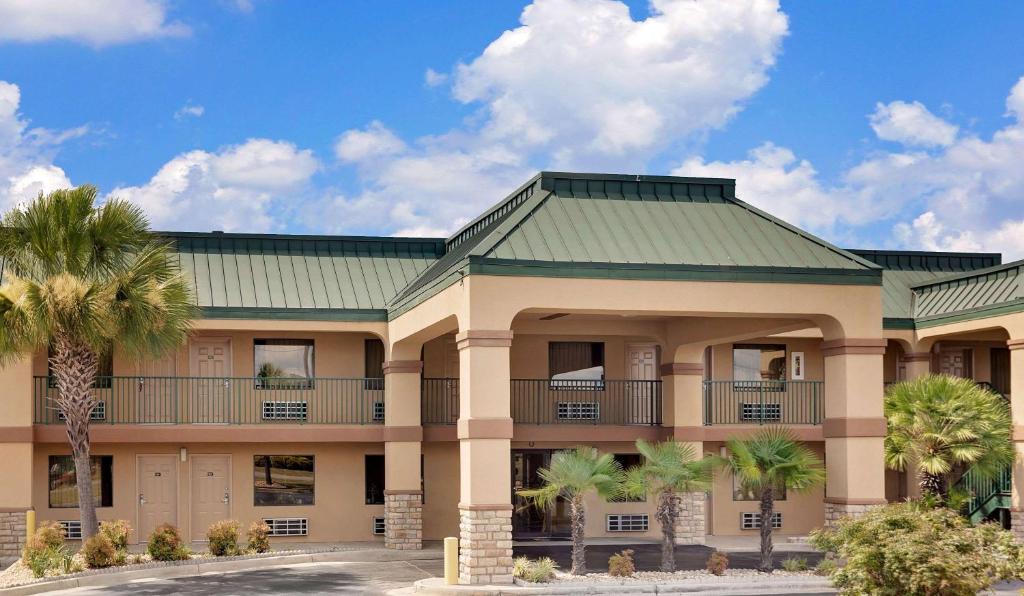 a building with palm trees in front of it at Super 8 by Wyndham Byron/South Macon in Byron