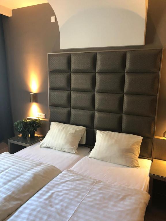 ケルステルバッハにあるHotel Athen Kelsterbach Frankfurt Airportのベッドルーム1室(ベッド2台、大型ヘッドボード付)