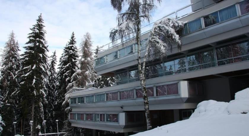 a building covered in snow with trees in front of it at Appartamento Sole Alto in Marilleva