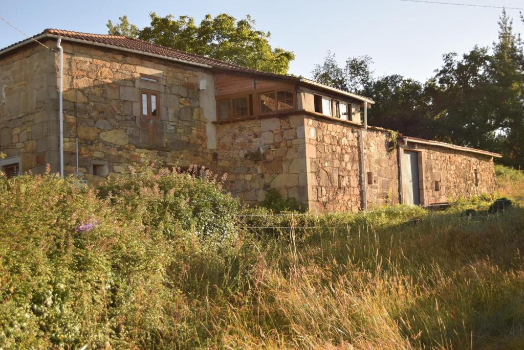 una casa de piedra sentada en la cima de un campo en O Fogar do Monte, en Sober
