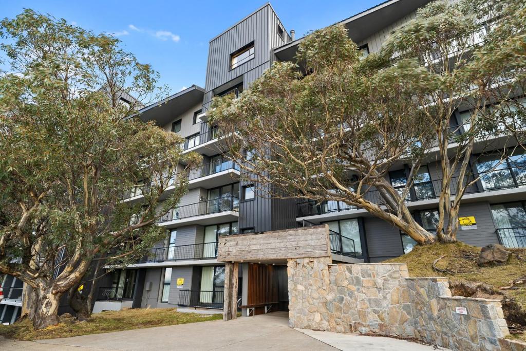 an apartment building with trees in front of it at Chalet Apartments - Mt Buller Apartment Rentals in Mount Buller