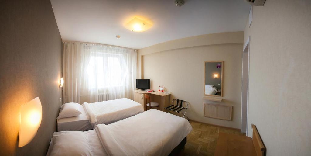 a hotel room with two beds and a window at AZIMUT Hotel Siberia in Novosibirsk