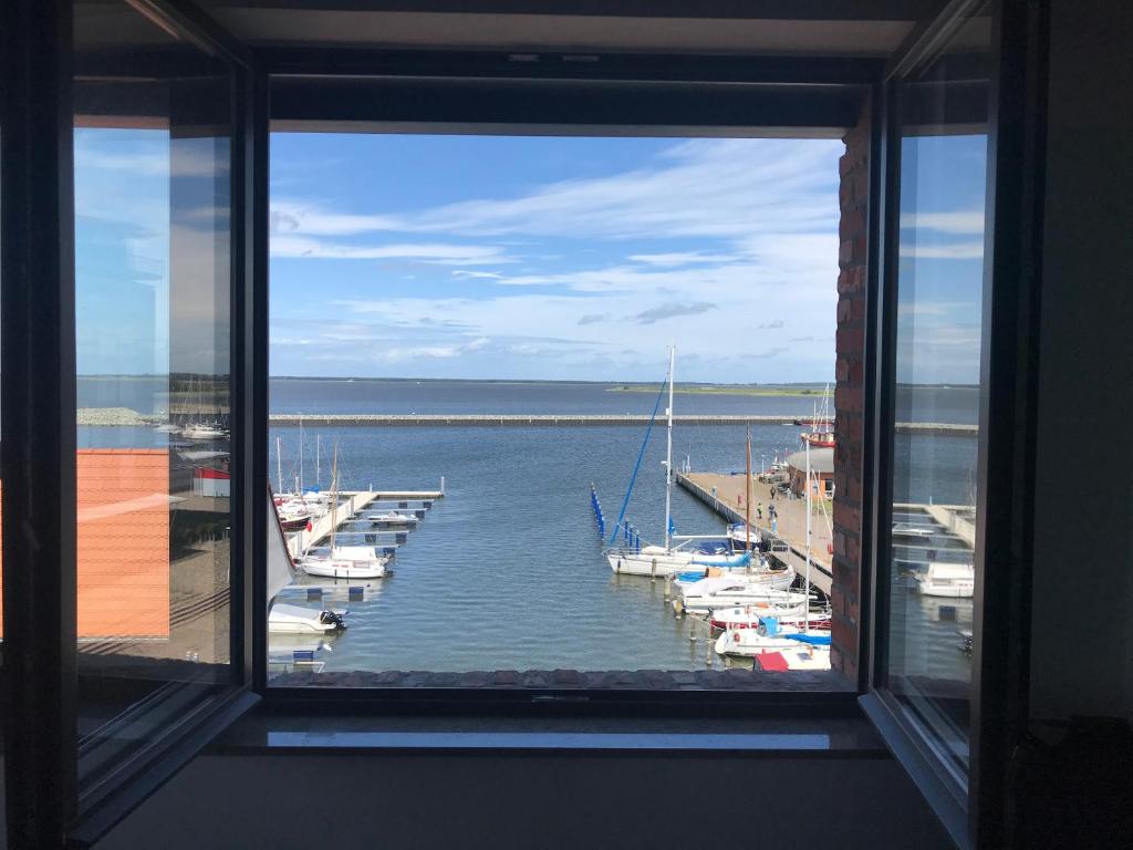 ein Fenster mit Blick auf einen Yachthafen mit Booten im Wasser in der Unterkunft Speicher Residenz Barth E4 App 4 in Barth