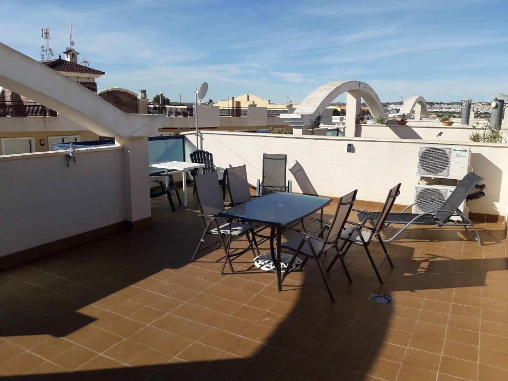 a balcony with a table and chairs on a roof at Playamarina 2 Cabo Roig in Playas de Orihuela