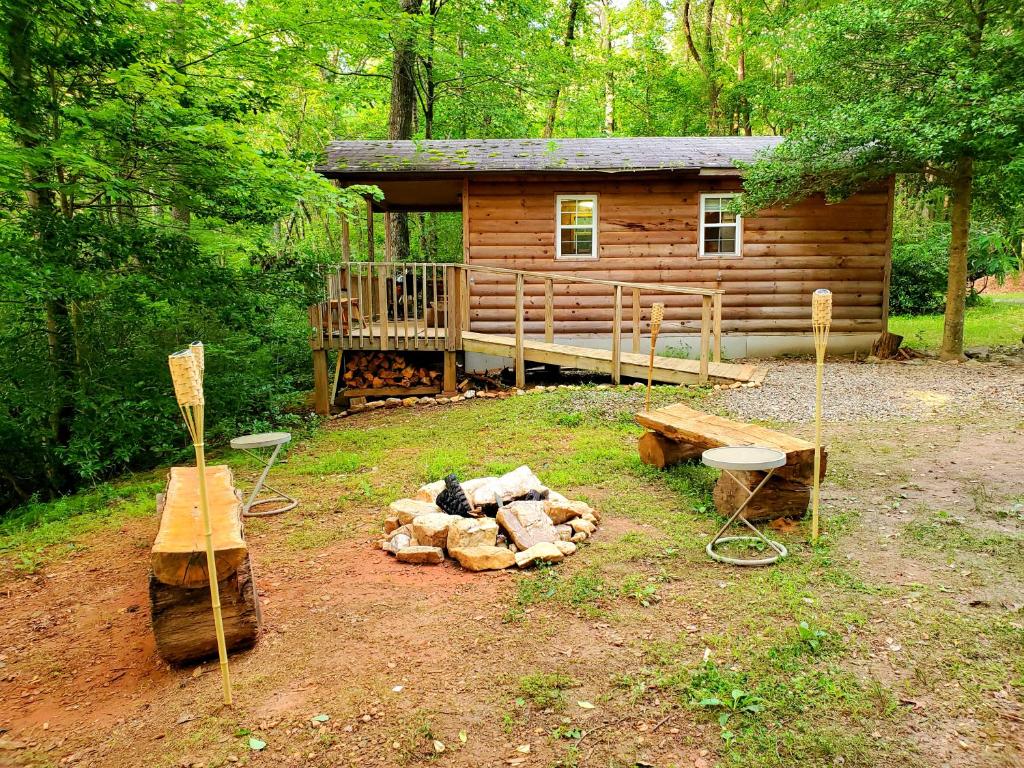 a log cabin with a fire pit in front of it at Lil' Log at Hearthstone Cabins and Camping - Pet Friendly in Helen