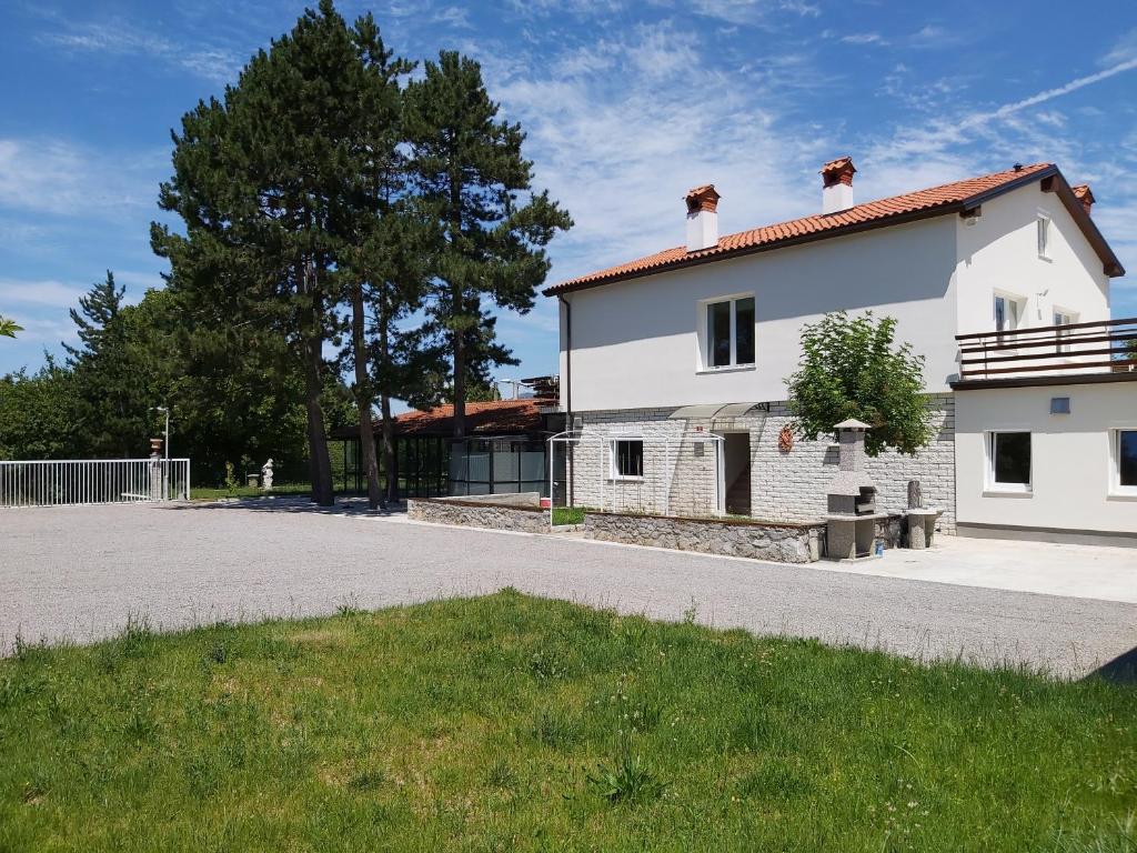 uma casa branca com uma árvore em frente em Divača, Vila Srebrna em Divača