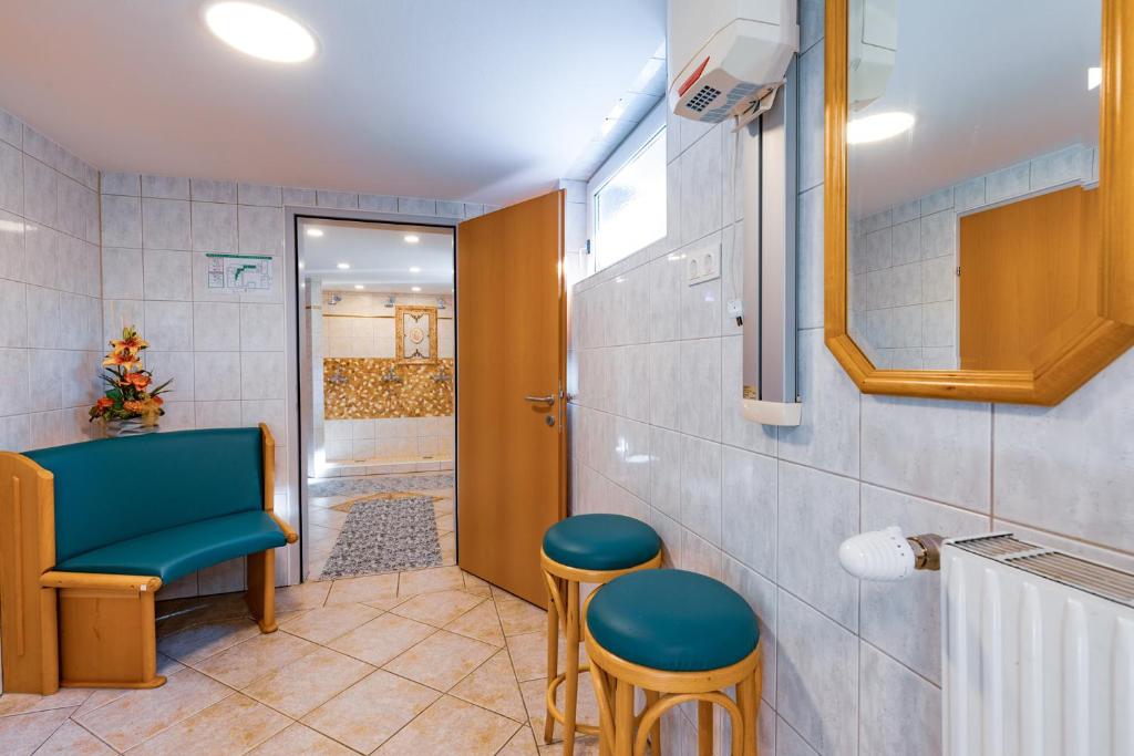 a bathroom with a blue bench and two stools at Hotel Freiensteinerhof Superior in Sankt Peter-Freienstein