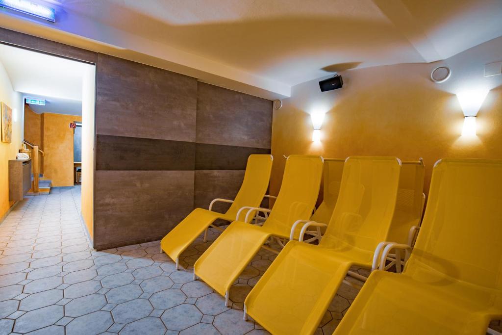 a row of yellow chairs in a waiting room at Hotel Freiensteinerhof Superior in Sankt Peter-Freienstein