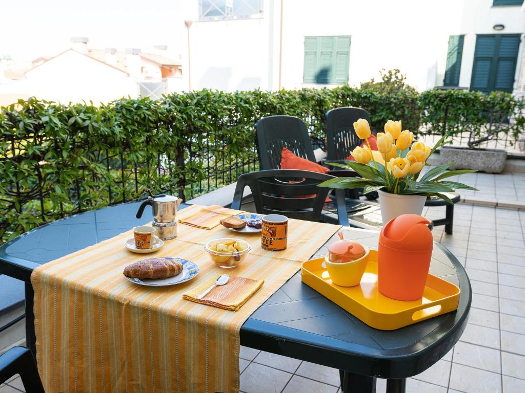een tafel met een dienblad met eten op een patio bij Terrazza del Gelsomino with terrace and open view in Borghetto Santo Spirito