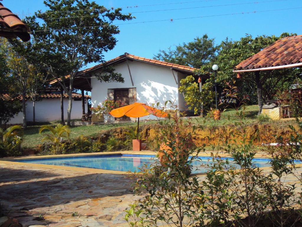 巴里查拉的住宿－巴里查拉科利納斯鄉村民宿，一座带遮阳伞的别墅前的游泳池