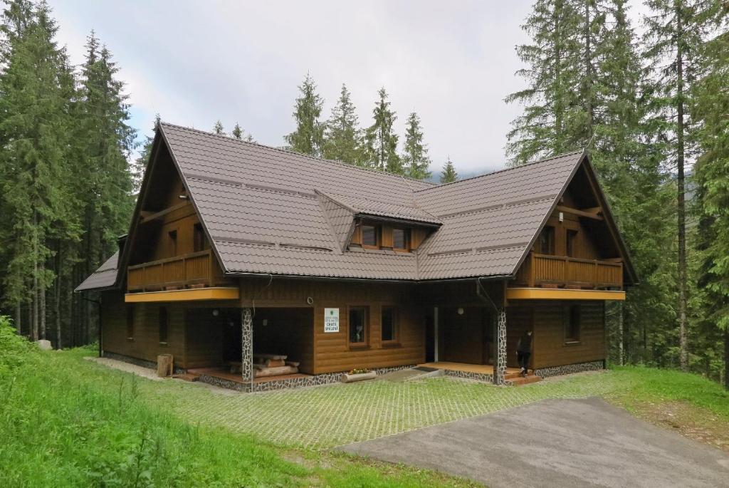 une maison en rondins avec un toit en gambrel dans l'établissement Chata Spálená, à Zuberec