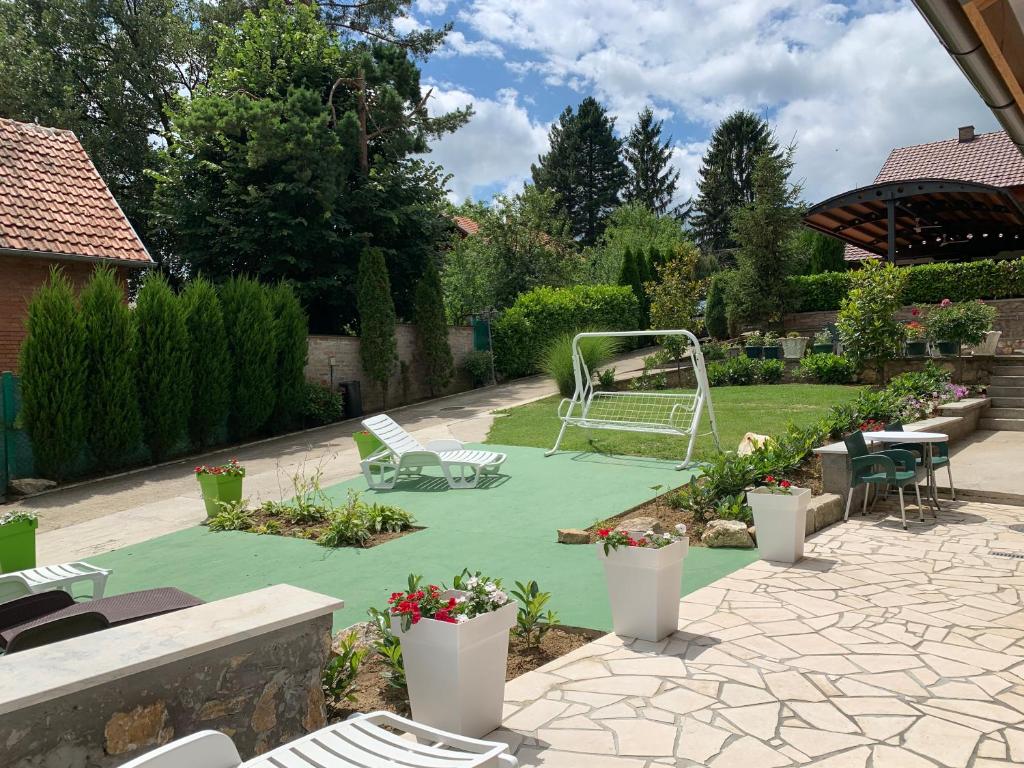 a backyard with a playground with a swing at Kuća za odmor "Karalic" in Ležimir
