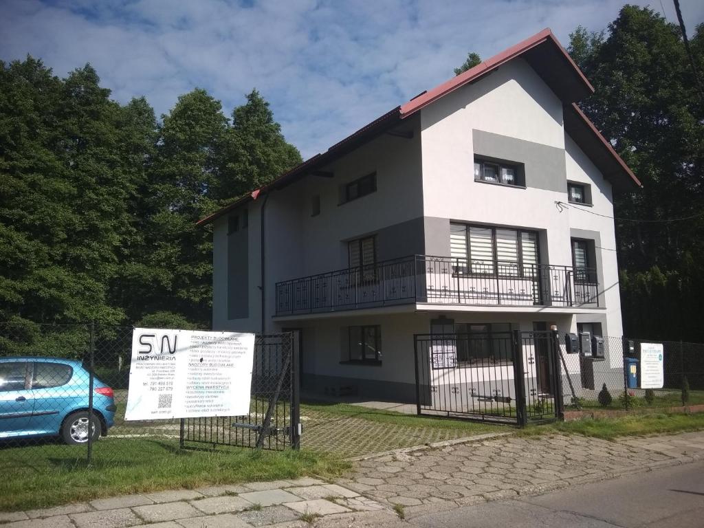 a white house with a sign in front of it at Dom w Cygańskim Lesie in Bielsko-Biała