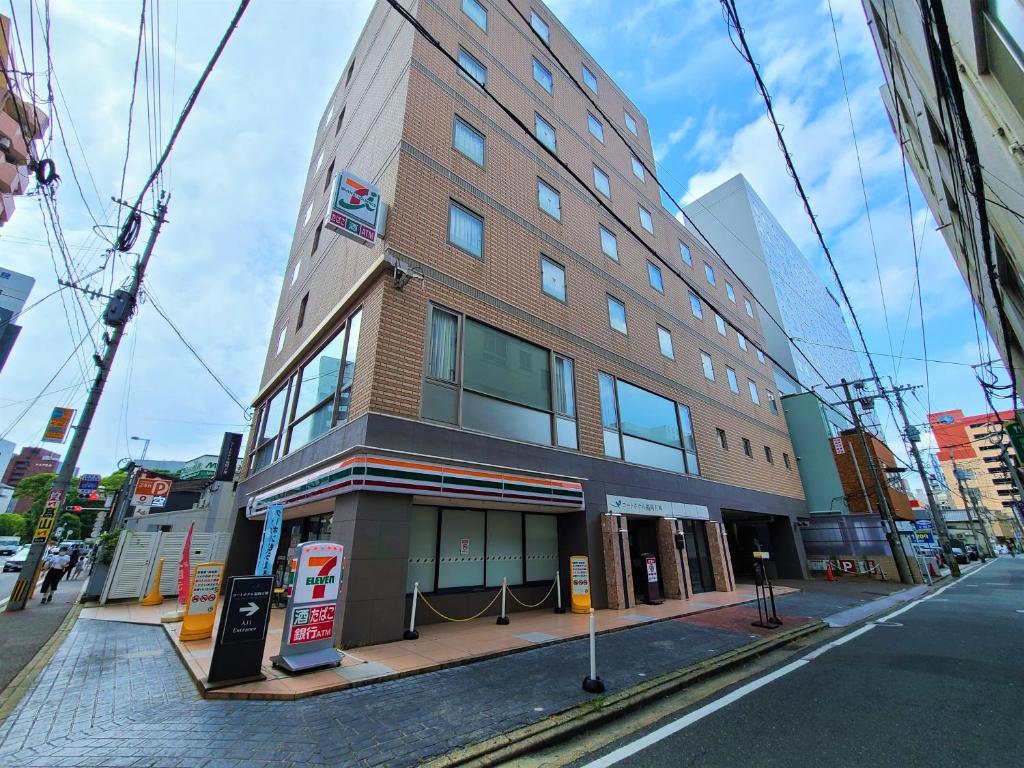 un grand bâtiment en briques sur une rue de la ville dans l'établissement Court Hotel Fukuoka Tenjin, à Fukuoka