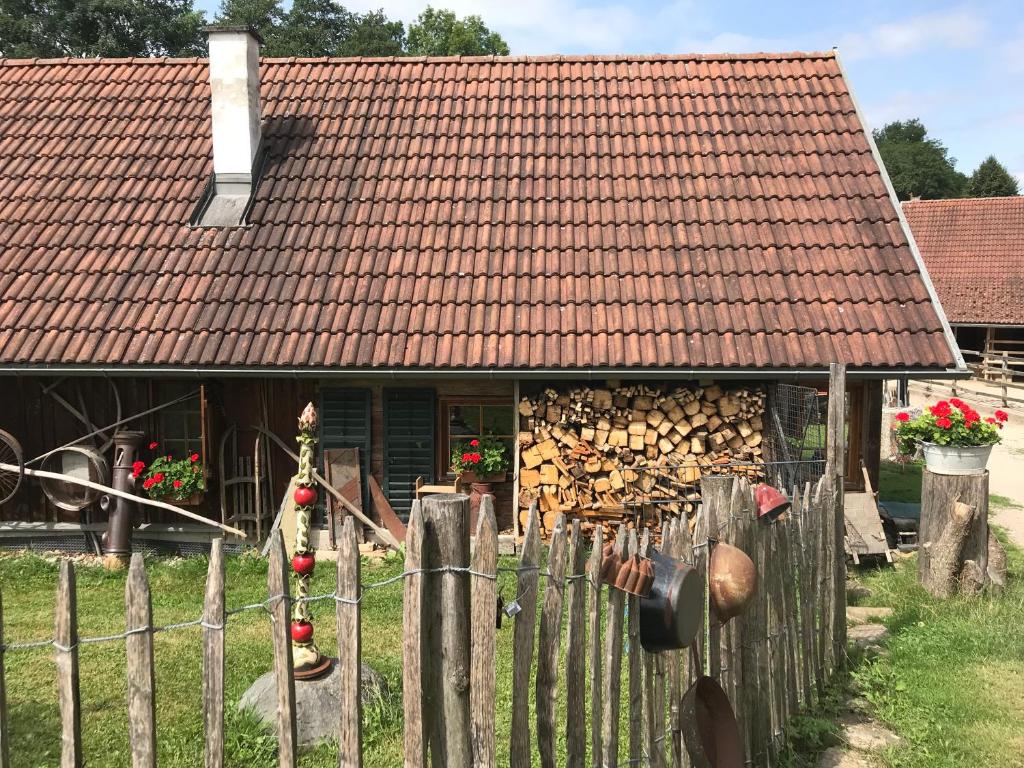ein Haus mit einem Holzzaun und einem Haus mit einem Dach in der Unterkunft Getreidekasten auf einer Lamafarm in Oberndorf an der Melk