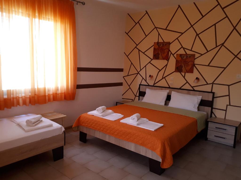 a hotel room with two beds and a window at Villa Anastasia in Limenas