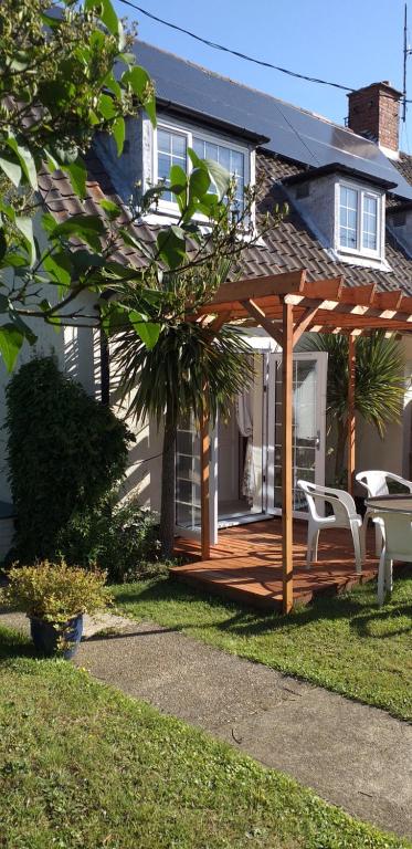 a wooden gazebo in the yard of a house at Crow Corner in Yoxford