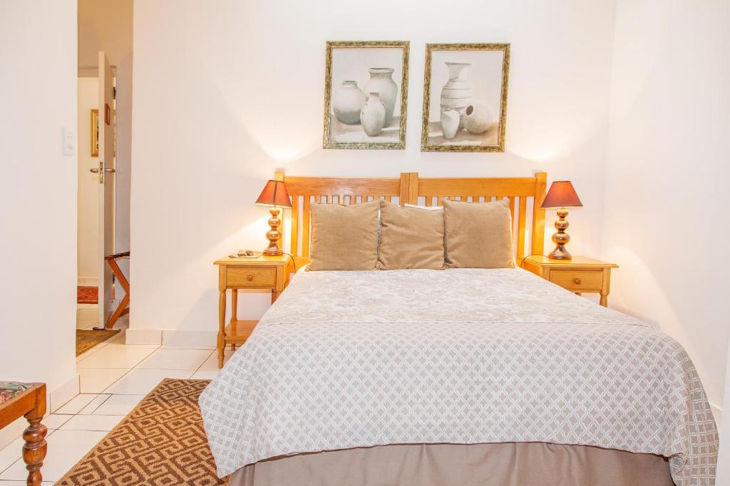 ein Schlafzimmer mit einem großen Bett mit zwei Nachttischen in der Unterkunft Rivendell Bed and Breakfast in Hillcrest