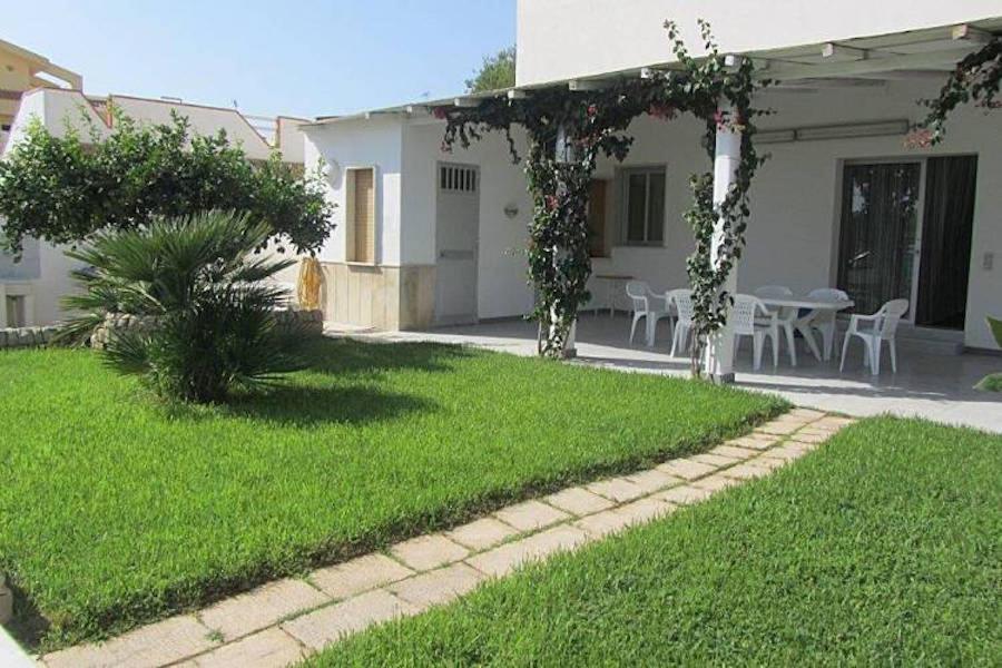 um quintal com uma casa com uma mesa e cadeiras em Casa Ancora - Le chiavi degli Iblei em Punta Braccetto