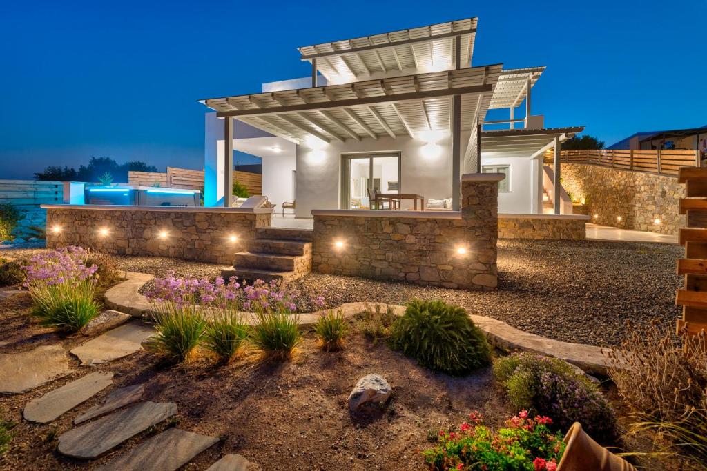 ein Haus mit einer Pergola und einem Garten in der Nacht in der Unterkunft Aelion Villa in Vári