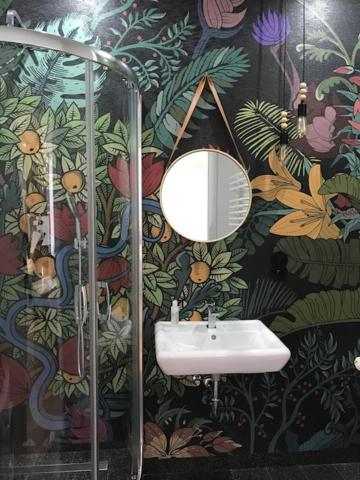 a bathroom with a sink and a floral wallpaper at Apartamenty Numer 6 in Lublin